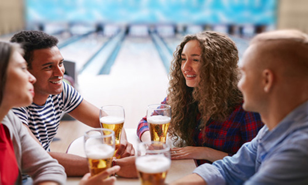 adults bowling with beer